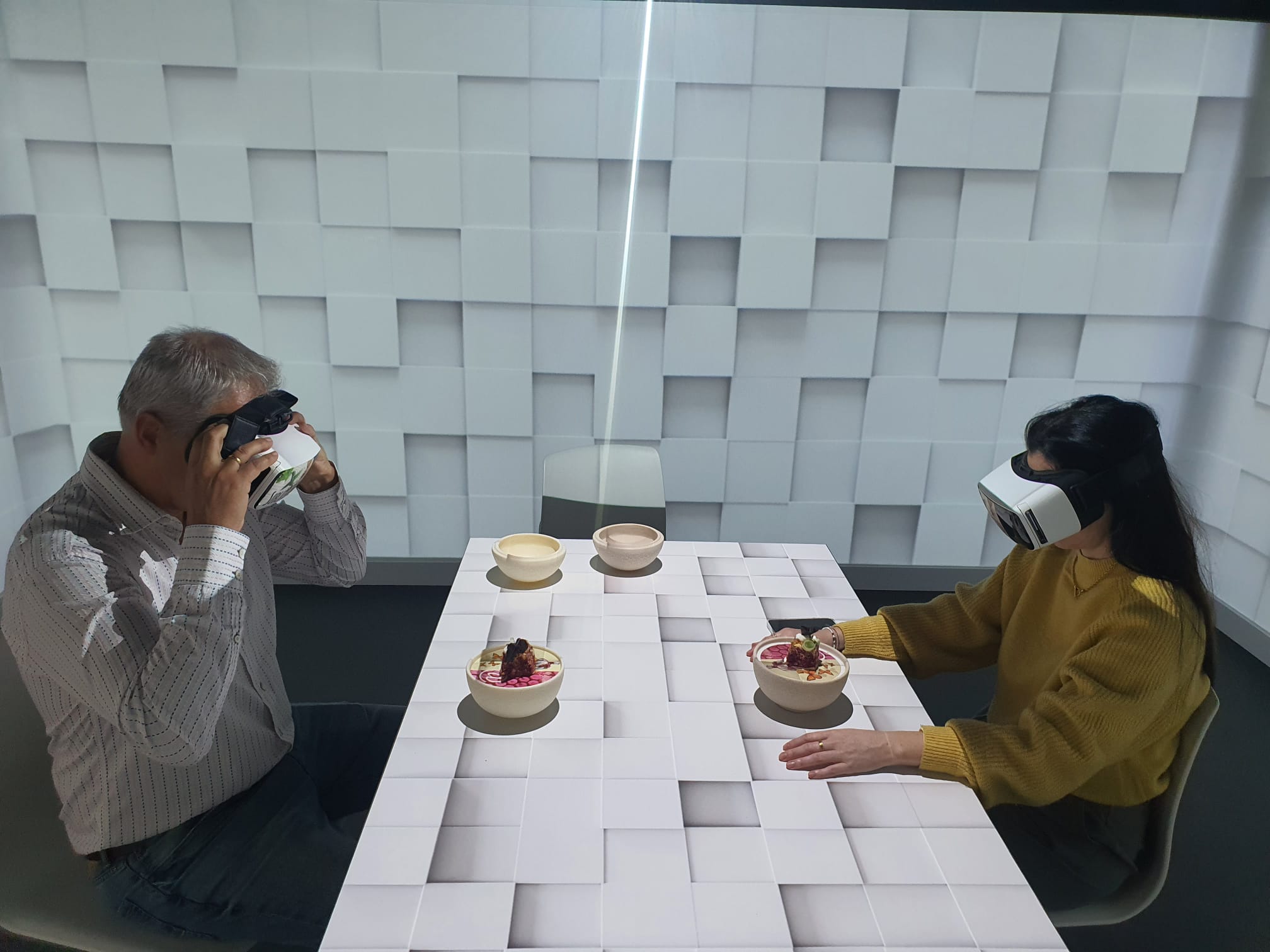 Dos participantes con gafas de realidad virtual prueban platos en una sesión de cata en el laboratorio